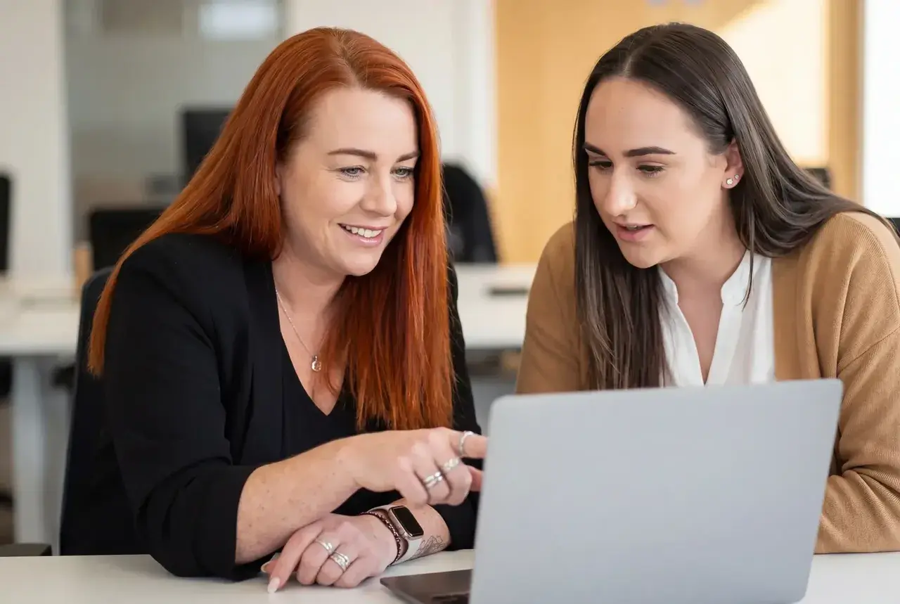Two PurpleTree HR advisors reviewing a client's case together at a laptop